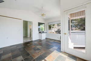 Unfurnished sunroom featuring vaulted ceiling and a sink