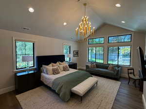 Primary Bedroom with dark wood finished floors, recessed lighting, a chandelier, and a vaulted ceiling