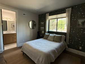 Bedroom featuring ensuite bath and wood finished floors
