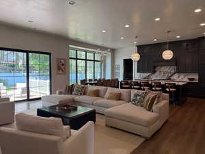 Living room with dark wood-style floors, a chandelier, and recessed lighting
