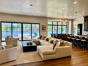 Living room with a chandelier, dark wood-style flooring, and recessed lighting