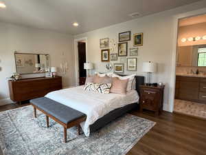 Bedroom with wood finished floors, recessed lighting, and ensuite bath