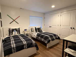 Bedroom featuring wood finished floors, a closet, and recessed lighting