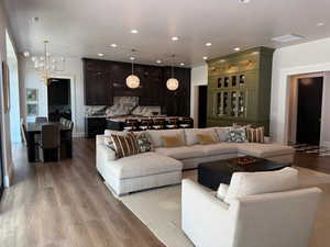 Living area featuring a chandelier, wood finished floors, and recessed lighting