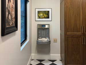 Mudroom with drinking fountain, built-in storage for shoes, coats, and general storage items, and a built-in retractable dog gate.