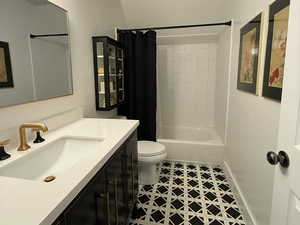 Full bath with tile patterned floors, vanity, and shower / bath combo