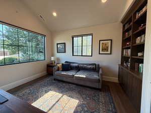 Living area featuring plenty of natural light, dark wood-style floors, lofted ceiling, and recessed lighting