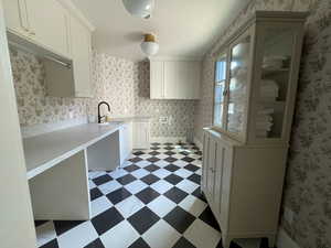 Main level laundry room with space for 4 oversized rolling hampers under folding counters.