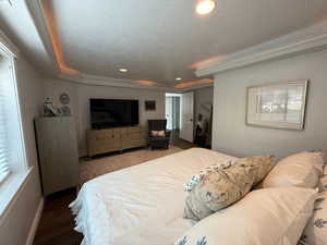 Bedroom with a textured ceiling, a closet, recessed lighting, and wood finished floors