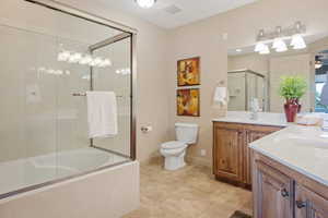 Bathroom featuring vanity and enclosed tub / shower combo