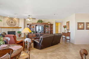 Living room featuring a ceiling fan and a tile fireplace