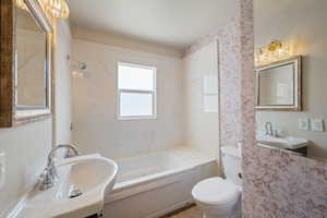 Full bathroom with a bath and toilet