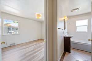 Full bath featuring vanity, tub / shower combination, and wood finished floors