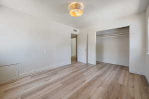 Unfurnished bedroom with light wood-type flooring and a closet