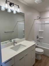 Full bath featuring wood finished floors, vanity, and bathtub / shower combination
