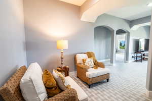 Living area with arched walkways and carpet