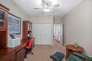 Office area with light carpet and a ceiling fan