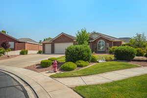 Ranch-style home featuring concrete driveway, an attached garage, and brick siding