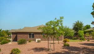 View of property exterior featuring brick siding and a tile roof