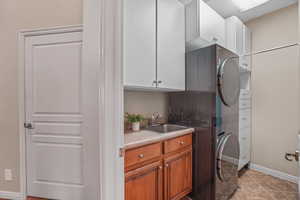 Laundry area with stacked washer / dryer and cabinet space