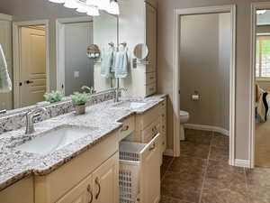 Full bath featuring double vanity and toilet
