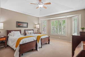 Carpeted bedroom featuring baseboards and a ceiling fan