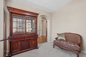 Sitting room with arched walkways and carpet floors