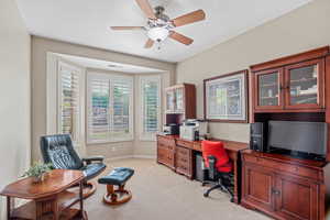 Office area with a ceiling fan, light carpet, and a textured ceiling