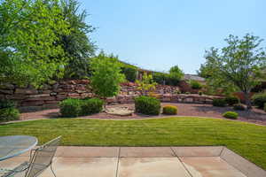 View of grassy yard featuring a patio