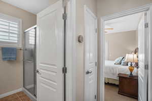 Full bathroom featuring connected bathroom and a stall shower