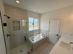 Full bath with a garden tub, a stall shower, recessed lighting, and double vanity
