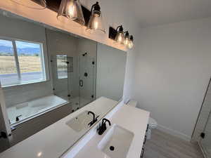 Bathroom featuring a stall shower, a bath, and vanity