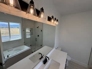 Full bathroom featuring a stall shower, a bath, vanity, and wood finished floors