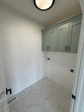 Laundry room featuring hookup for an electric dryer, cabinet space, and washer hookup