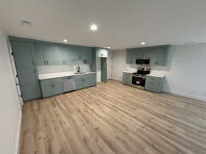 Kitchen featuring appliances with stainless steel finishes, light wood-style flooring, recessed lighting, and light countertops