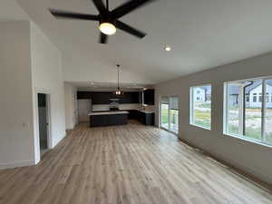 Unfurnished living room with light wood-style floors, ceiling fan, recessed lighting, and high vaulted ceiling