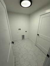 Laundry room with electric dryer hookup, washer hookup, and light tile patterned floors