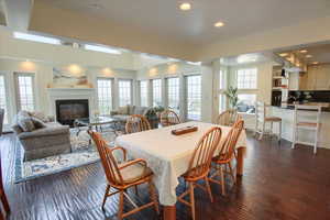 Dining area featuring recessed lighting, a glass covered fireplace, plenty of natural light, and dark wood-type flooring