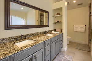 Bathroom with double vanity, recessed lighting, and a shower