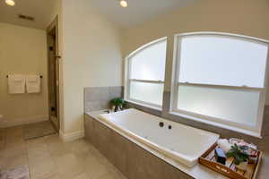 Full bath with a garden tub, lofted ceiling, tile patterned floors, a shower, and recessed lighting