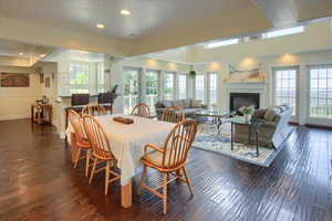 Dining area featuring dark wood-type flooring, recessed lighting, and a glass covered fireplace