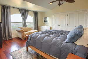Bedroom with wood finished floors, lofted ceiling, two closets, recessed lighting, and a ceiling fan
