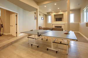 Recreation room featuring a fireplace, healthy amount of natural light, and recessed lighting