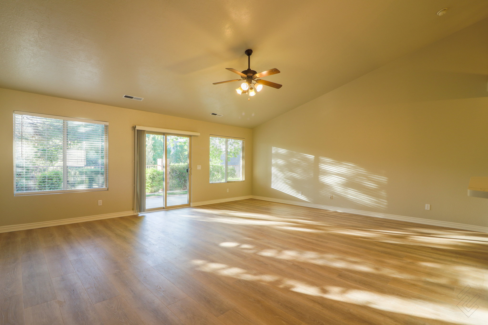 Spare room featuring light wood-style floors, ceiling fan, and vaulted ceiling