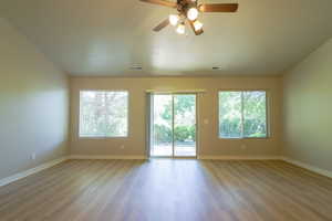 Spare room with ceiling fan, light wood-style flooring, and lofted ceiling