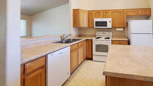Kitchen featuring white appliances and light countertops
