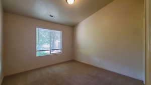 Spare room featuring light colored carpet and baseboards
