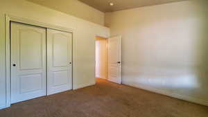 Unfurnished bedroom with carpet and a closet