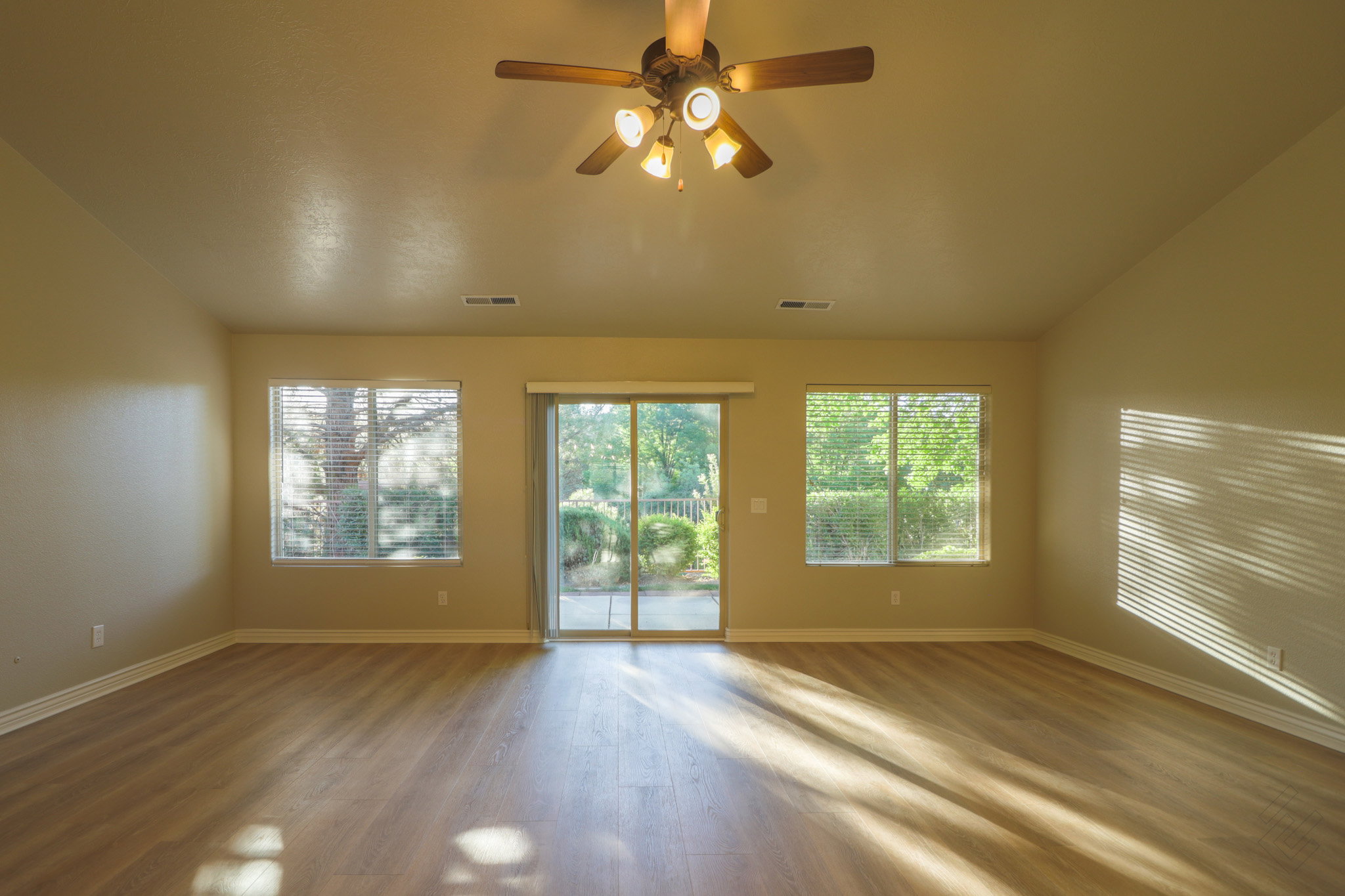 Spare room featuring dark wood-style floors, plenty of natural light, a ceiling fan, and lofted ceiling