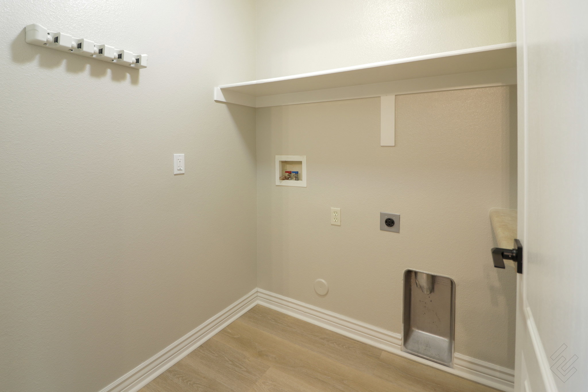 Laundry area with light wood finished floors, washer hookup, and hookup for an electric dryer